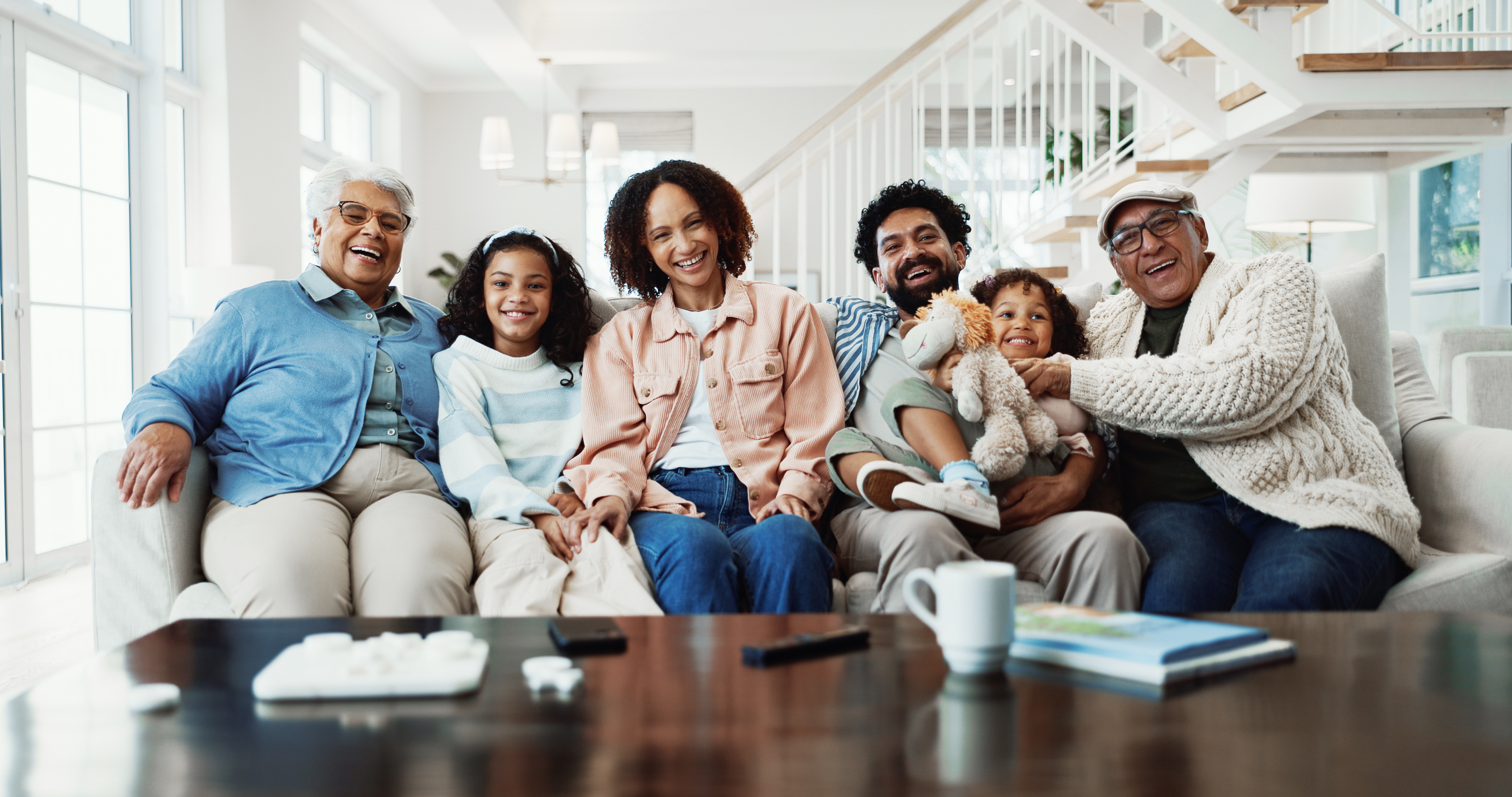 Familia de varias generaciones sonriendo en un sofá